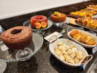 Un buffet de pasteles y otros postres en un mostrador. en Flat Beira Mar em Boa Viagem - Belíssima vista para o MAR, en Recife