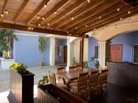 een patio met een houten tafel en stoelen bij Bugambilias Hotel Hacienda in Durango