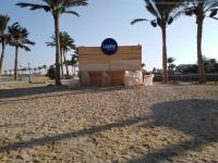 un cartel en una playa con palmeras en el fondo en فيلا خاصة بمنتجع هوليداي ان فانتازيا - راس سدر باطلالة على البحر, en Ras Sedr