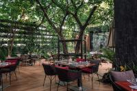 Un restaurante con mesas y sillas en un patio. en Parc Borough City Resort, en Chiang Mai