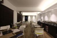 a restaurant with tables and white chairs and a counter at Spring Hill Hotel and Service Apartments in Dhaka