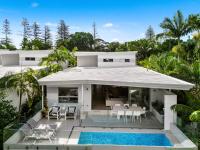 a white house with a swimming pool and a villa at Fat Frog Beach Houses in Byron Bay