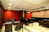 uma sala de jantar com paredes vermelhas e mesas e cadeiras em Watermark Hotel & Spa Bali em Jimbaran