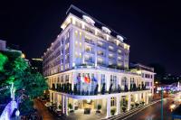 a large white building on a city street at night at Hotel de l'Opera Hanoi - MGallery in Hanoi