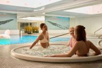 drei Frauen sitzen in einem Whirlpool in einem Schwimmbad in der Unterkunft Waterlane Riverside - SPA, Pool, Gym &amp; Parking by Downtown Apartments in Danzig