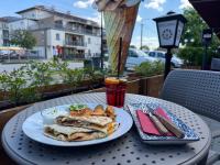 a plate of food on a table with a drink at Solaris Garden Rooms in Cserkeszőlő