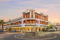 Un gran edificio con una fuente delante. en The Rose Hotel &amp; Motel, en Bunbury