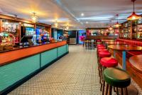 een bar met rode en groene krukken in een restaurant bij Aurora on the Dunes- Cozy Coastal Retreat with Scenic Views in Lossiemouth