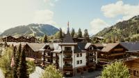 Una vista aérea de un complejo turístico con montañas al fondo. en Miiro The Mansard, en Gstaad