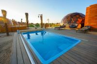 einen Pool auf einer Terrasse mit zwei Kuppeln in der Unterkunft Al Marmoom Oasis Luxury Experiential Desert Domes in Dubai