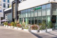 um edifício com um monte de vasos de plantas na frente dele em Luxury Waterfront 3BR, Pool, Canal Views! Yas Island em Abu Dhabi