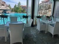 un patio con tavoli, sedie e vista sull'acqua di Vineyard Spa Resort Aheloy - Muscat-6 Studio a Kableshkovo