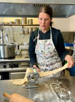 a woman in a kitchen making a dough at Familiehotel La Randulina in Ramosch