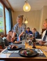 a woman sitting at a table with plates of food at Familiehotel La Randulina in Ramosch