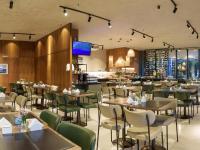 a restaurant with tables and chairs and a bar at Flat Hotel Athos Bulcão in Brasilia