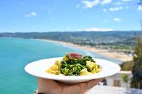 Una persona sosteniendo un plato de comida con una playa en Vieste Rooftop - Sea view near Pizzomunno - Free private Parking, en Vieste