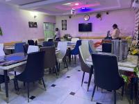 a dining room with tables and chairs and a tv at GRAND PARK HOTEL AND SUITEs in Egbe