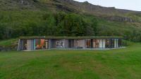 una casa en una colina con un campo verde en Klettasel Villa, en Hof