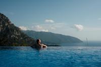 un hombre parado en el agua en el océano en Olive Garden Kabak, en Faralya