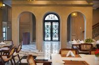 a restaurant with tables and chairs and a window at Alhamra Hotel in Mardan