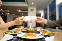 un gruppo di persone seduti a un tavolo con piatti di cibo di Coral Cove Hotel a Da Nang