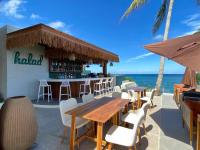 ein Restaurant am Strand mit Tisch und Stühlen in der Unterkunft Manggadiwa Resort and Spa in Tando