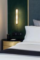 a bedroom with a bed and a light on a wall at Academias Hotel, Autograph Collection in Athens