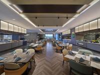 Un restaurante con mesas y sillas y una cafetería. en Hilton Jiashan, en Jiaxing
