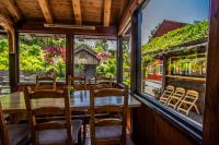 ロフトフースにあるウレンスヴァン ゲストハウスのテーブルと椅子と窓のあるダイニングルーム