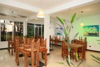 Un comedor con mesas y sillas de madera y una planta. en Greenfield Haven, en Nikawatawana