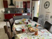 - une cuisine avec une table et de la nourriture et des boissons dans l'établissement Greg House 49 - Chambres d'Hôtes, à Beaupréau