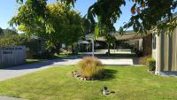 un edificio con un patio con un pájaro en el césped en Catlins Area Motel, en Owaka