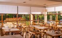 a restaurant with wooden tables and chairs and windows at Hotel Estel in Berga