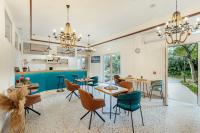 Un comedor con mesas y sillas y una cocina. en Hotel Subra Atrium, en Herceg-Novi