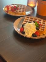 特伦德尔堡Gast- und Pensionshaus Pilgereck的一盘加奶油和浆果的华夫饼