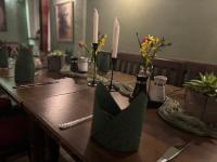 特伦德尔堡Gast- und Pensionshaus Pilgereck的一张长木桌,上面有蜡烛和鲜花