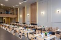 Un restaurante con mesas y sillas y una pantalla grande. en Howard Johnson Ciudad del Este, en Ciudad del Este