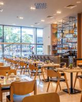 Un restaurante con mesas y sillas y un bar. en Howard Johnson Ciudad del Este, en Ciudad del Este