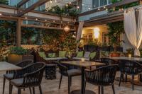 eine Terrasse mit Tischen, Stühlen und Pflanzen in der Unterkunft Iberostar Waves Miami Beach in Miami Beach