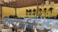 um restaurante com mesas, cadeiras e um bar em Hotel Wayira Beach by On vacation em Ríohacha