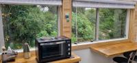 eine Mikrowelle auf einer Theke vor zwei Fenstern in der Unterkunft Rameka Chalet in Takaka