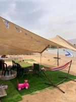 ein Zelt am Strand mit einem Tisch und einem Spielzeugauto in der Unterkunft קרוואן על הים in Eilat