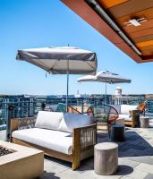 a patio with couches and umbrellas on a roof at The Morrow Washington Dc, Curio Collection By Hilton in Washington