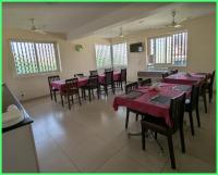 uma grande sala de jantar com mesas e cadeiras vermelhas em AVM Comforts Inn Koramangala em Bangalore