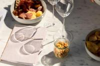 a table with two wine glasses and a bowl of food at NH Copenhagen Grand Joanne in Copenhagen