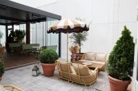 a patio with chairs and an umbrella on a patio at NH Copenhagen Grand Joanne in Copenhagen