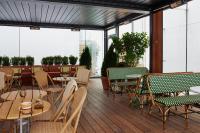 a patio with tables and chairs on a deck at NH Copenhagen Grand Joanne in Copenhagen