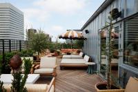 a patio with couches and an umbrella on a building at NH Copenhagen Grand Joanne in Copenhagen