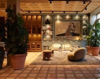 a living room with couches and a large screen at NH Copenhagen Grand Joanne in Copenhagen