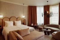 a hotel room with a bed and a couch at NH Copenhagen Grand Joanne in Copenhagen